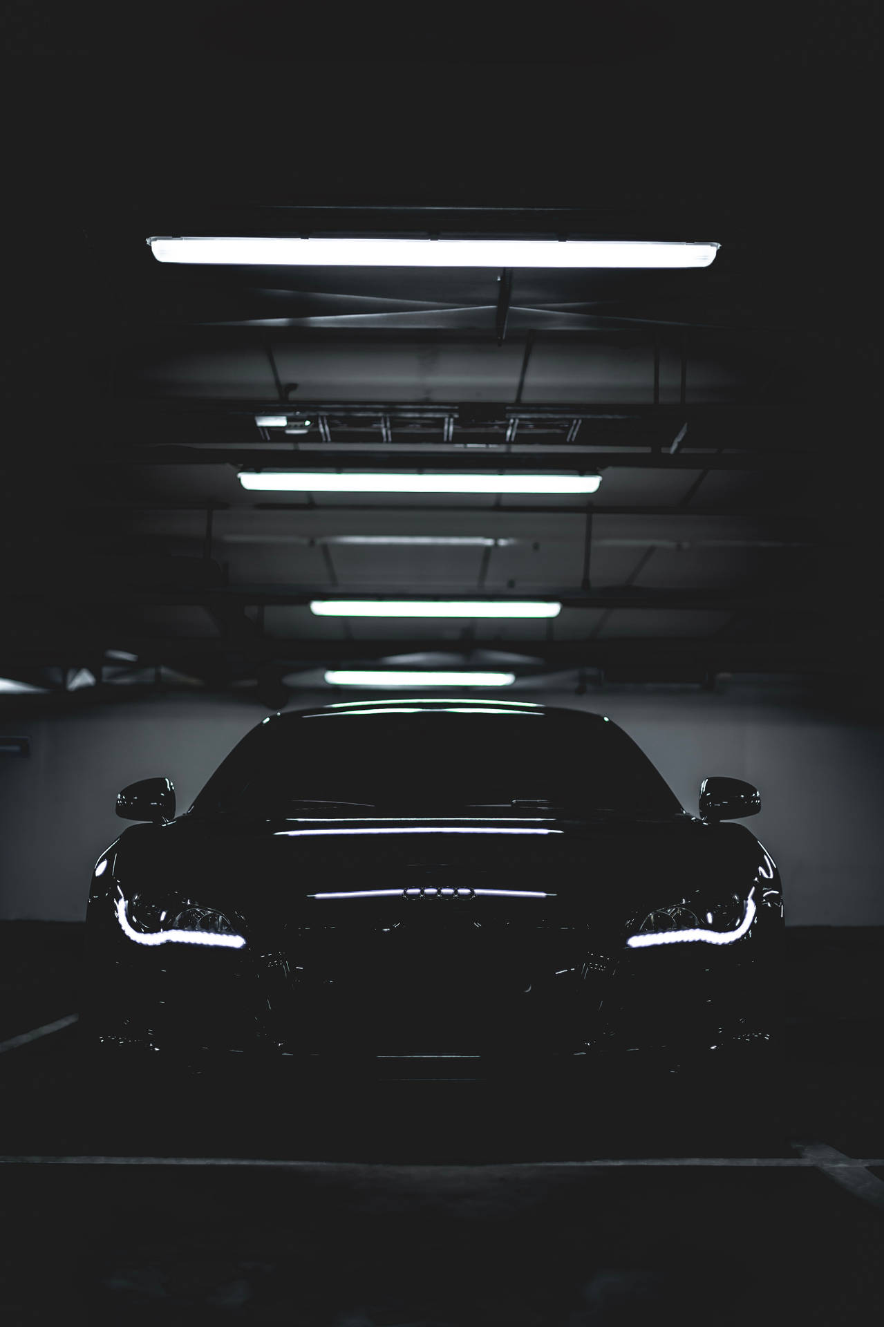 A Black Car In A Dark Parking Garage Wallpaper