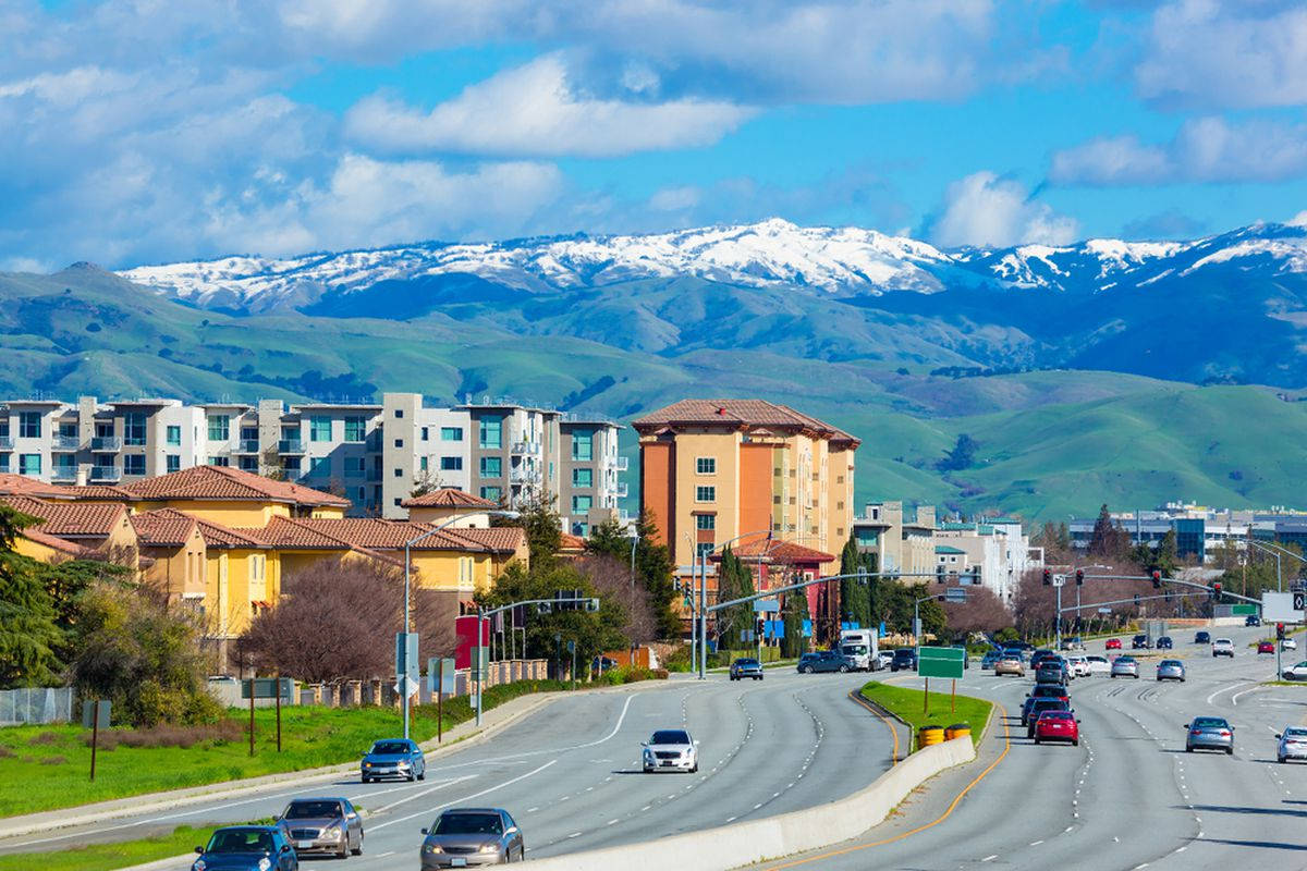 A City Street With A Mountain In The Background Wallpaper