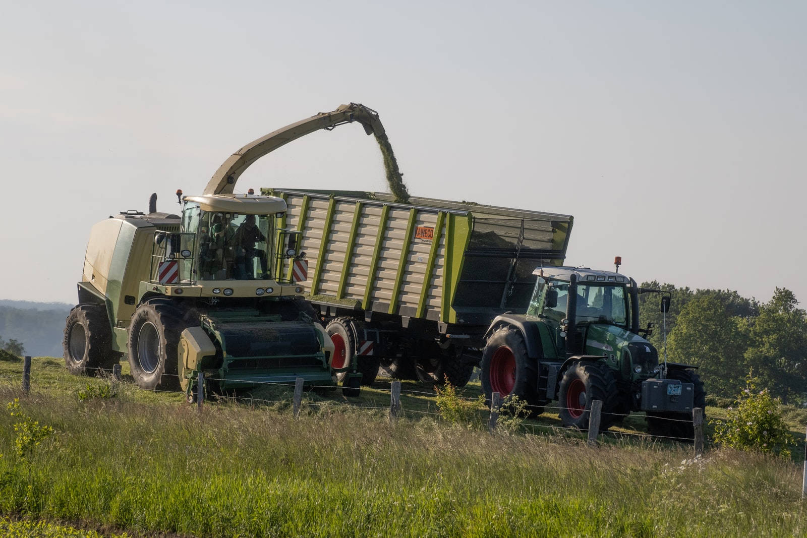 A Diligent Farmer Operating A Thresher On A Tractor In The Field. Wallpaper