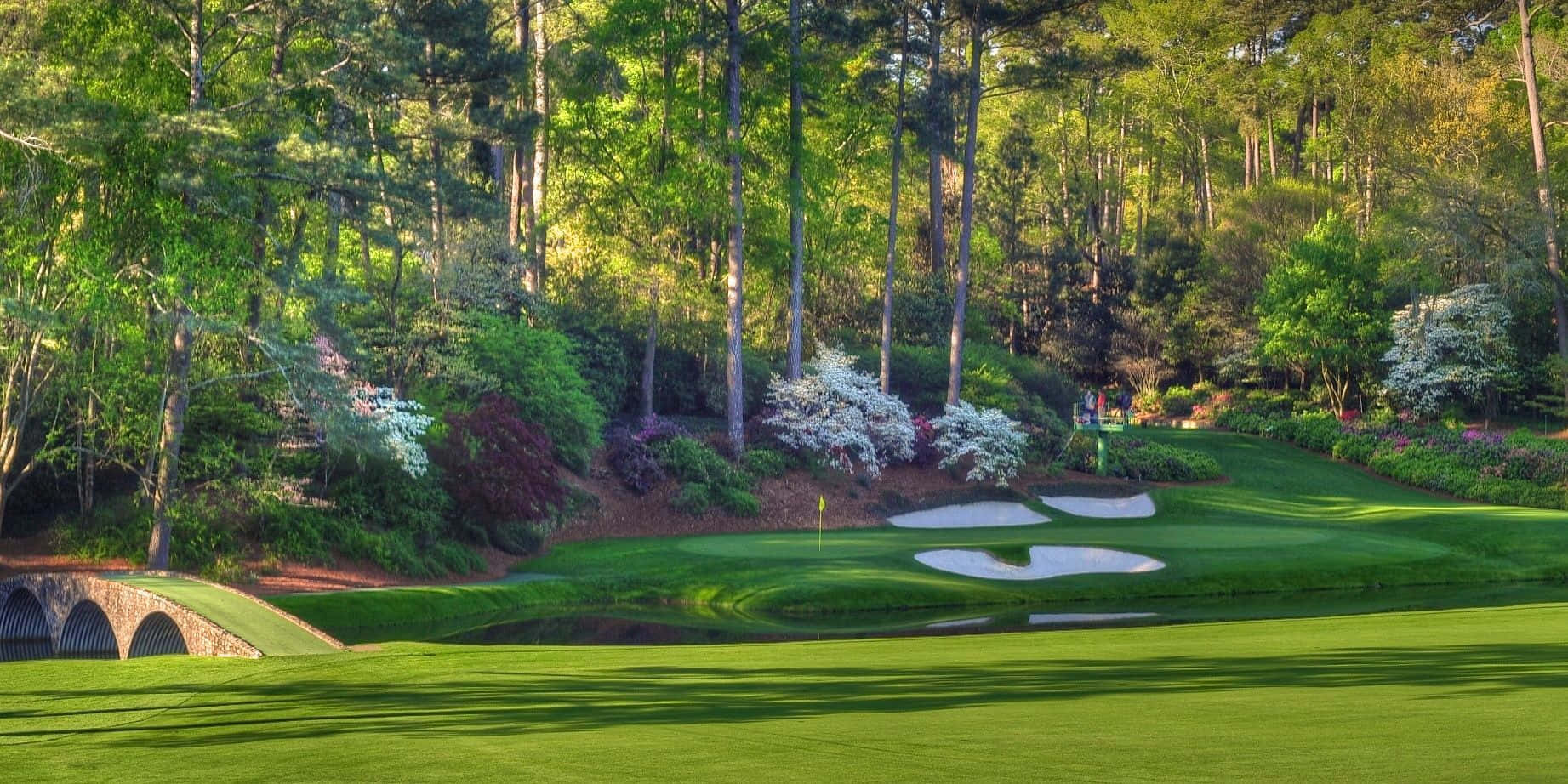 A Golf Course With A Bridge And Trees Wallpaper