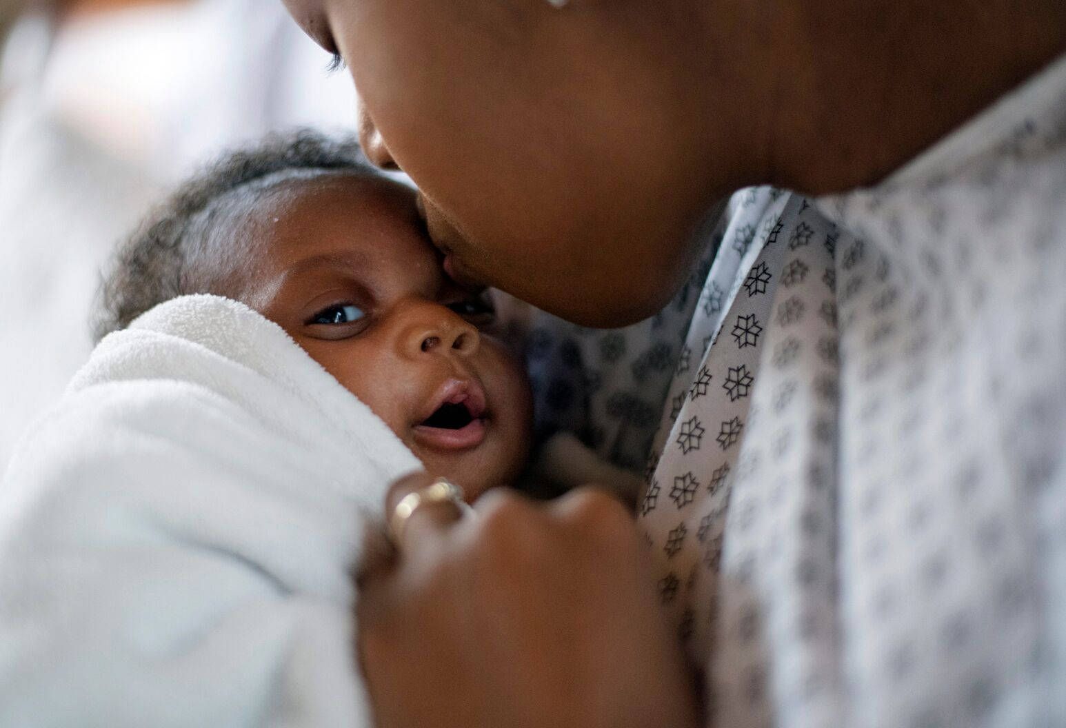 A Loving Moment Between A Smiling Mother And Her Swaddled Baby Wallpaper