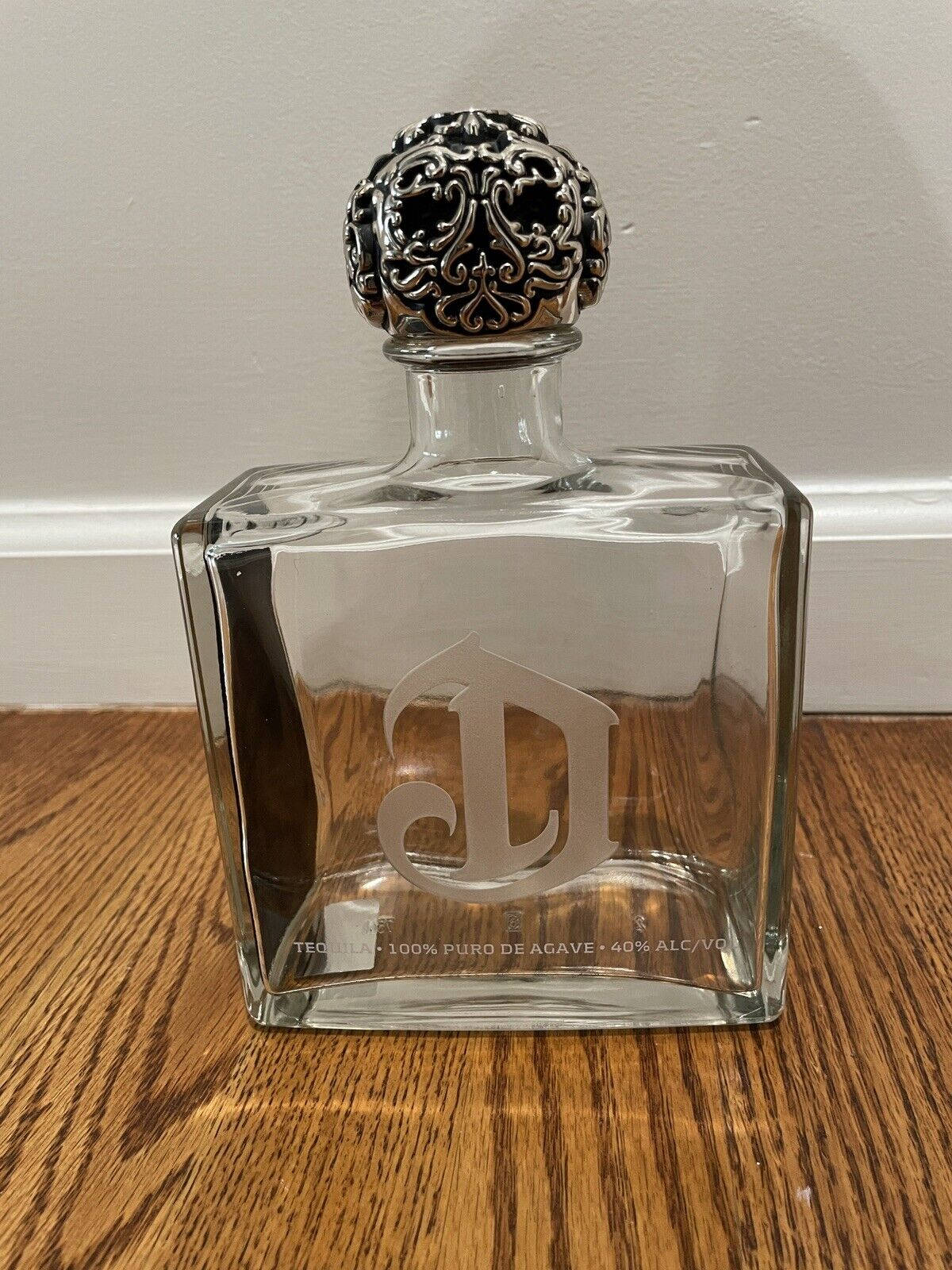 A Luxurious Deleon Tequila Bottle Elegantly Poised On A Wooden Surface. Wallpaper