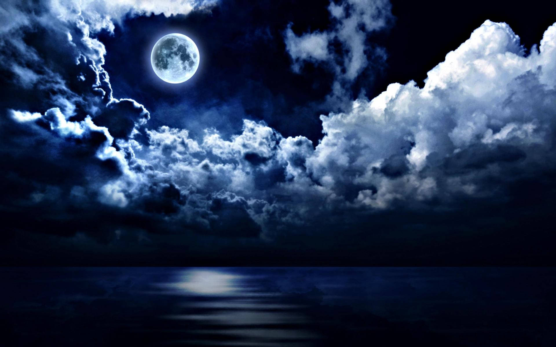 A Magical Blue Hue Is Illuminating The Full Moon Reflecting Off A Calm Night Sea. Wallpaper