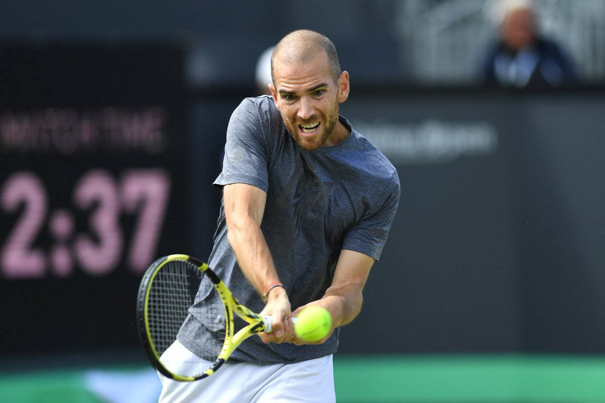 A Man Is Hitting A Tennis Ball Wallpaper