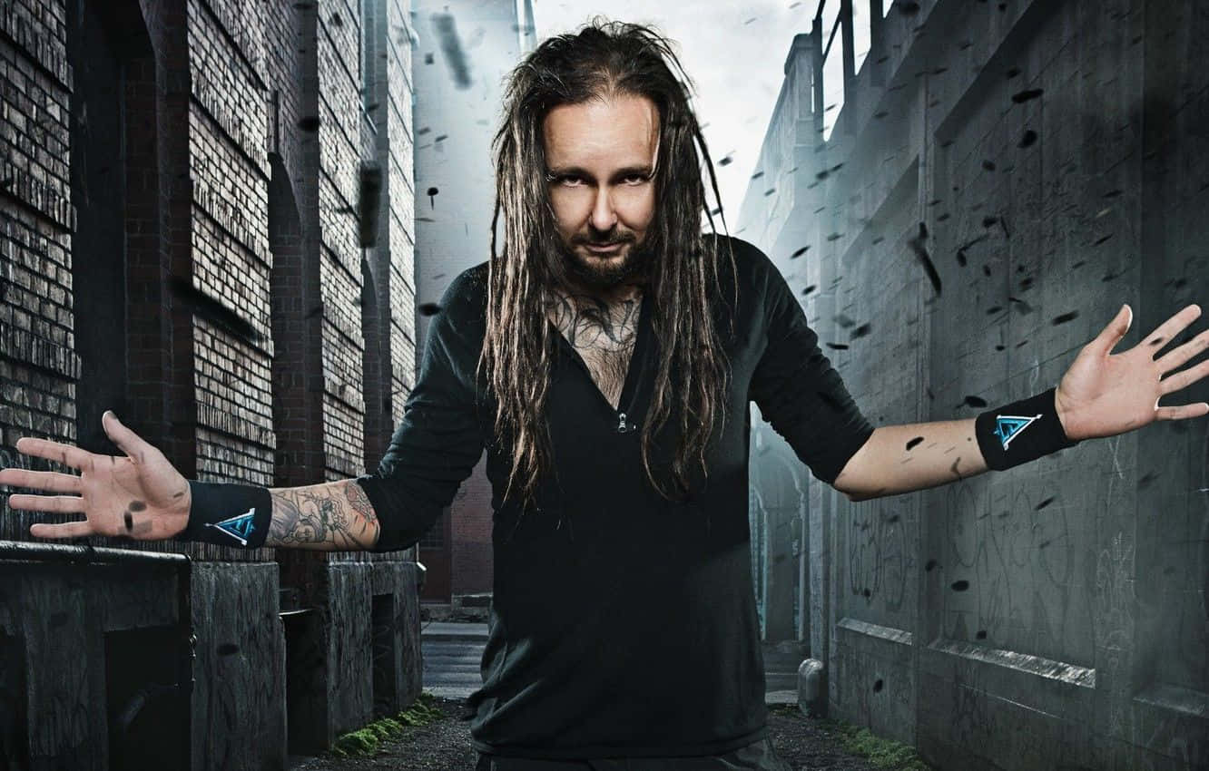 A Man With Dreadlocks Standing In An Alleyway Wallpaper