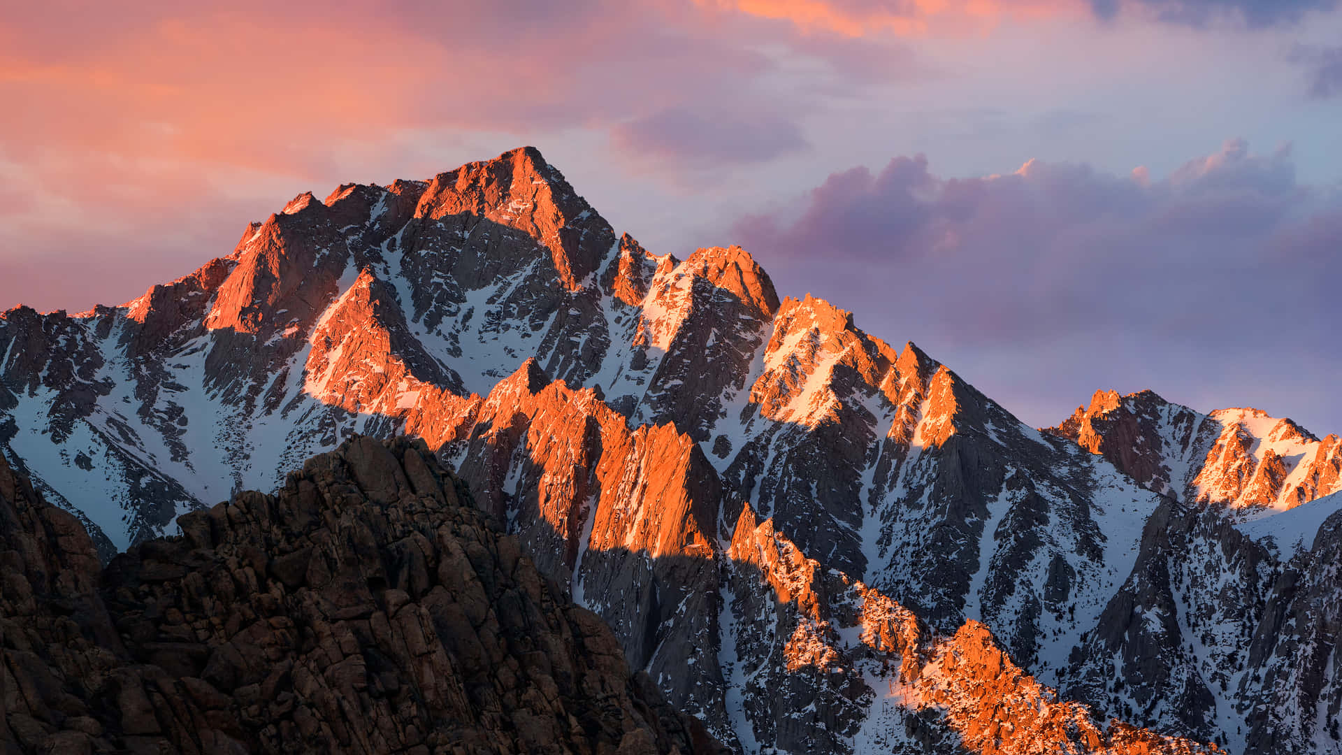 A Mountain Range With A Sunset In The Background Wallpaper