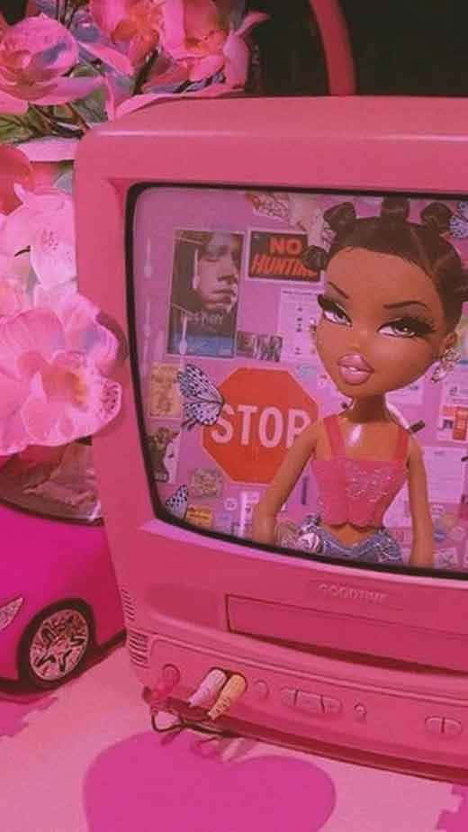 A Pink Television With A Doll Sitting On Top Wallpaper