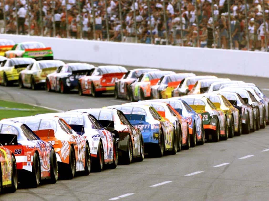 A Race Car Roars Around A Track During A Nascar Race Wallpaper