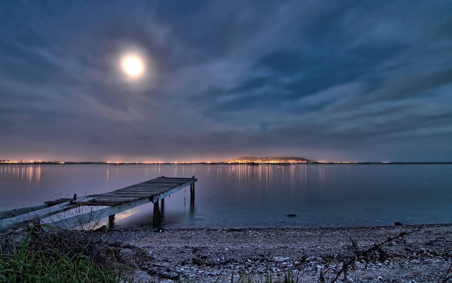 A Serene Night At The Beach Illuminated By Twinkling Lights Wallpaper