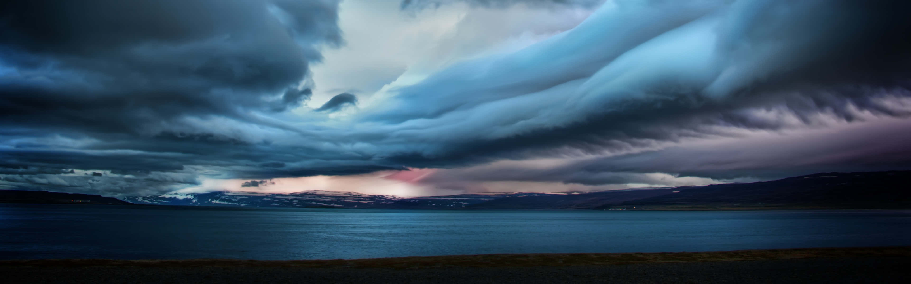 A Stormy Sky Over A Lake And Mountains Wallpaper