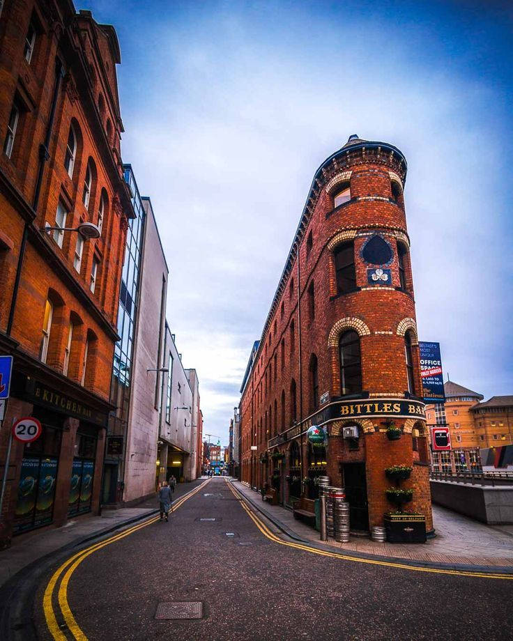 A Street With A Red Brick Building And A Clock Tower Wallpaper