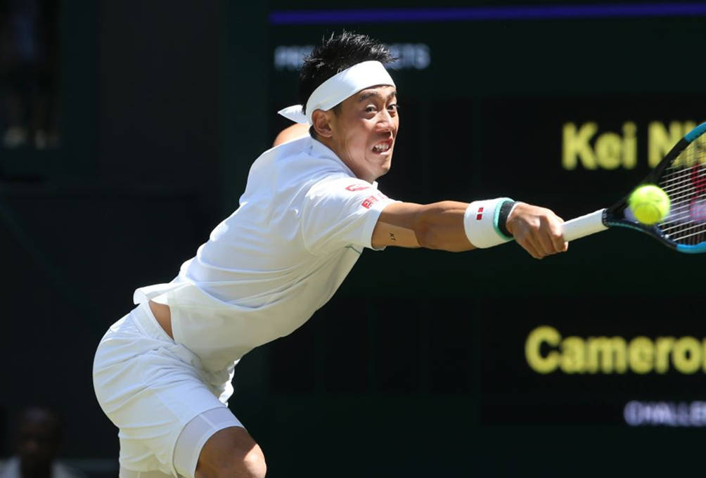 A Tennis Player Is Swinging His Racket At A Ball Wallpaper