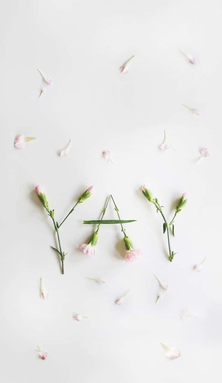 A White Background With Pink Flowers Arranged In The Shape Of The Word Yay Wallpaper
