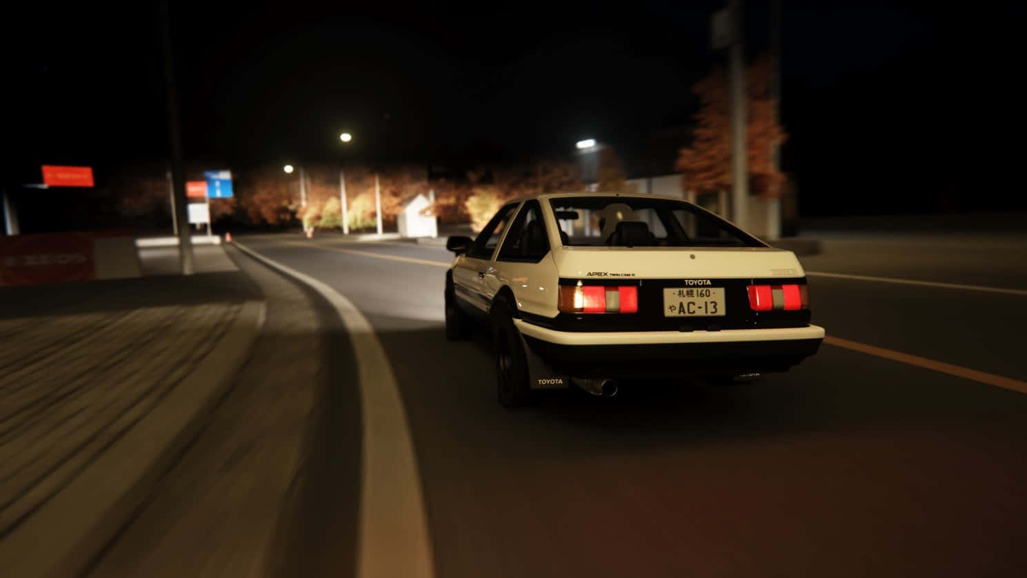 A White Car Driving Down The Street At Night Wallpaper