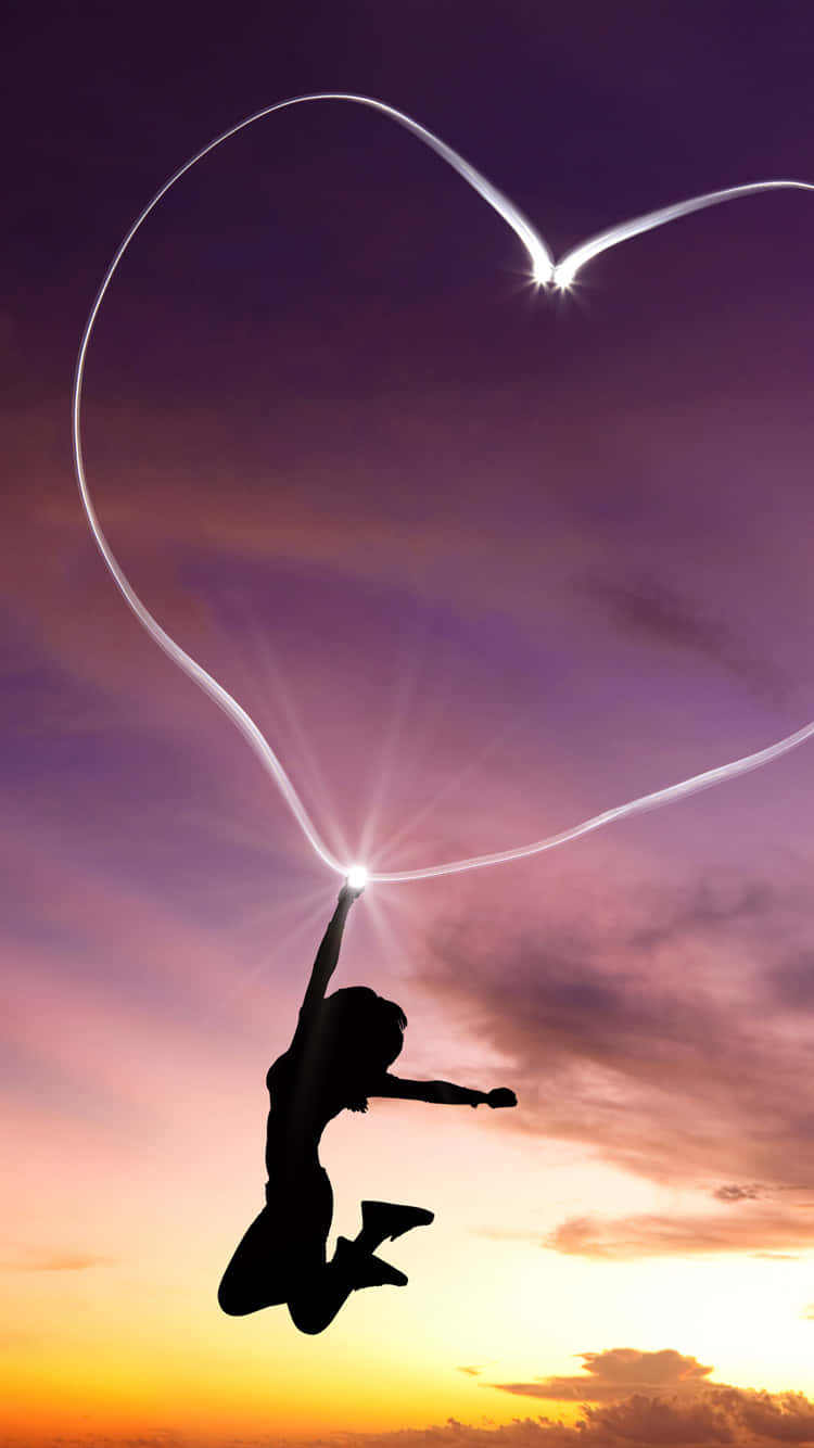 A Woman Jumping In The Air With A Heart Shaped Outline Wallpaper