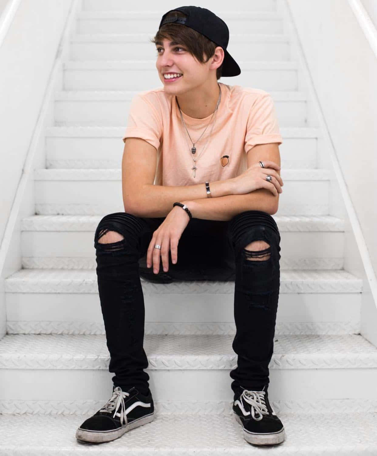 A Young Man Sitting On A Set Of Stairs Wallpaper