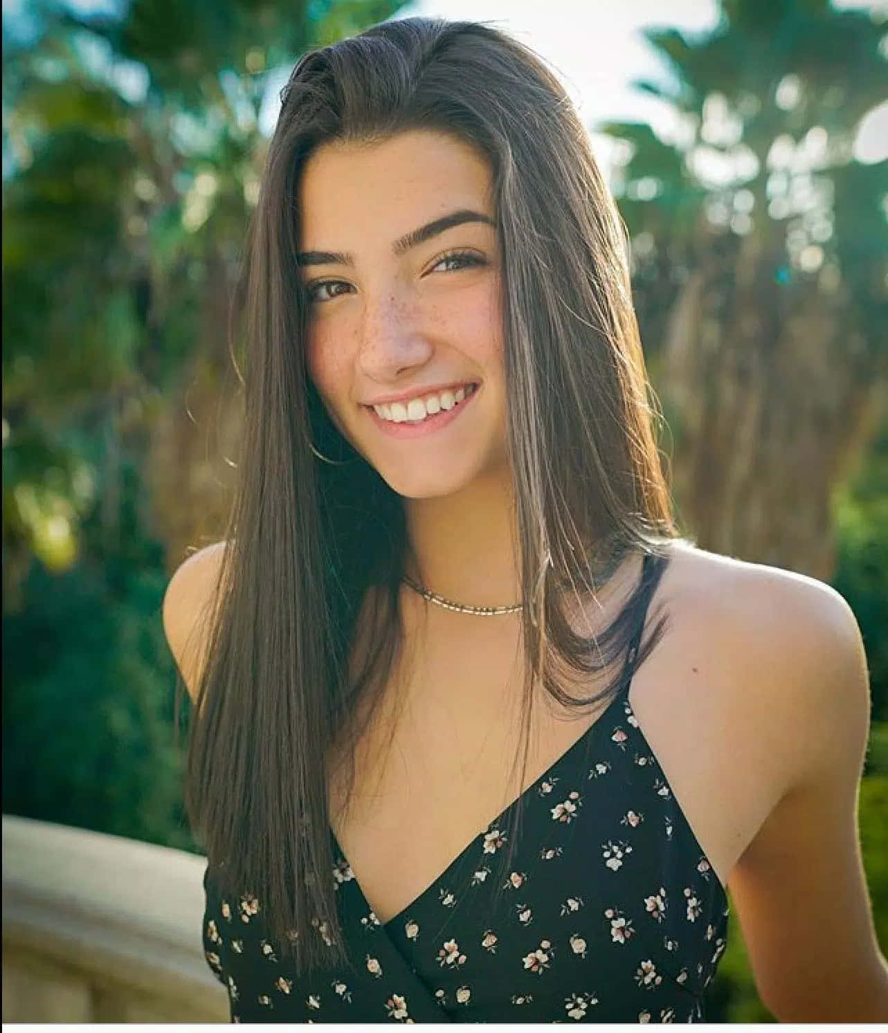 A Young Woman Smiling In Front Of Palm Trees Wallpaper