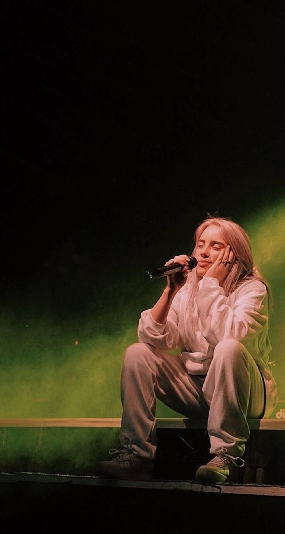 Aesthetic Billie Eilish Sitting On Stage Wallpaper