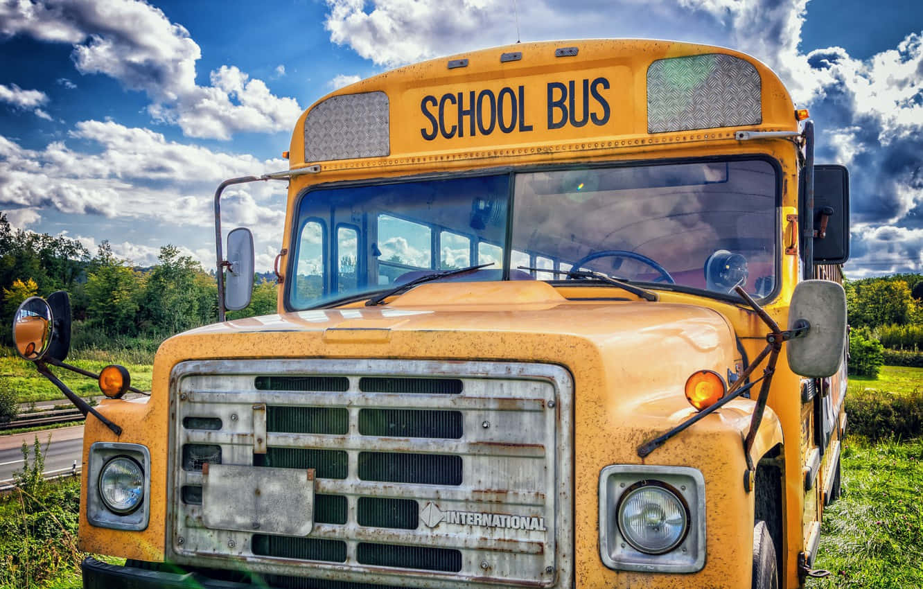 An Old School Bus Parked On A Road Wallpaper