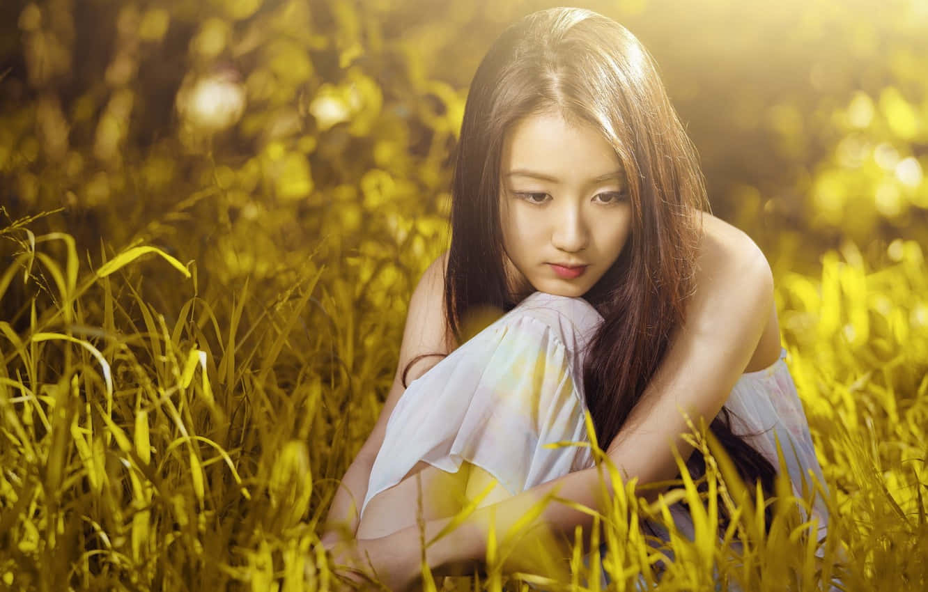 Asian Woman Sitting On Grass Wallpaper