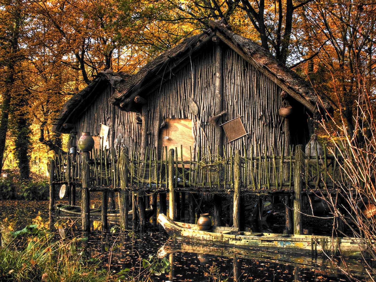 Authentic Tribal Wooden Houses Amidst Lush Greenery Wallpaper