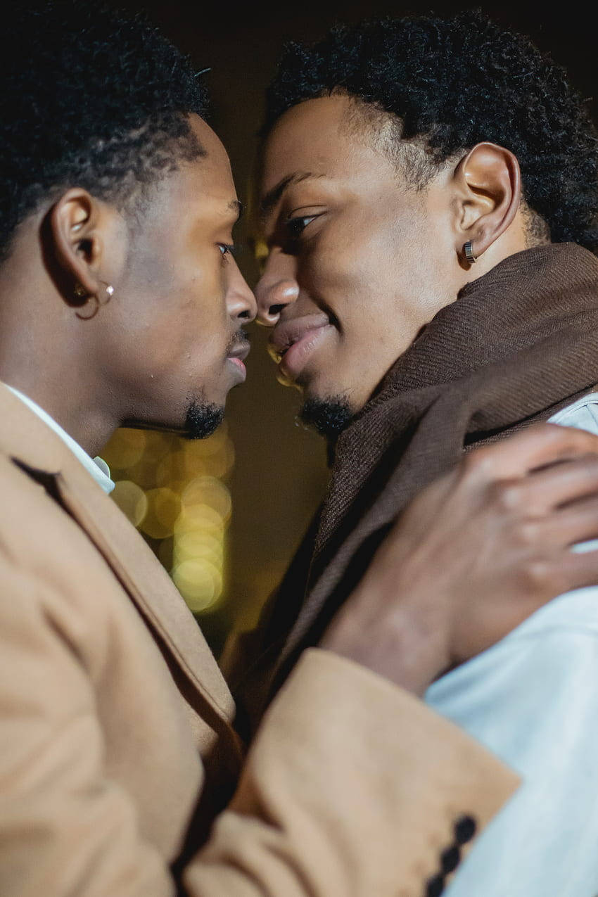 Black Gay Man In A Light Almond Suit With Partner Wallpaper