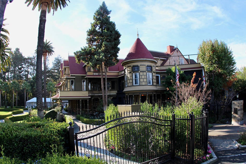 Caption: Historic Winchester Mystery House Surrounded By Greenery Wallpaper