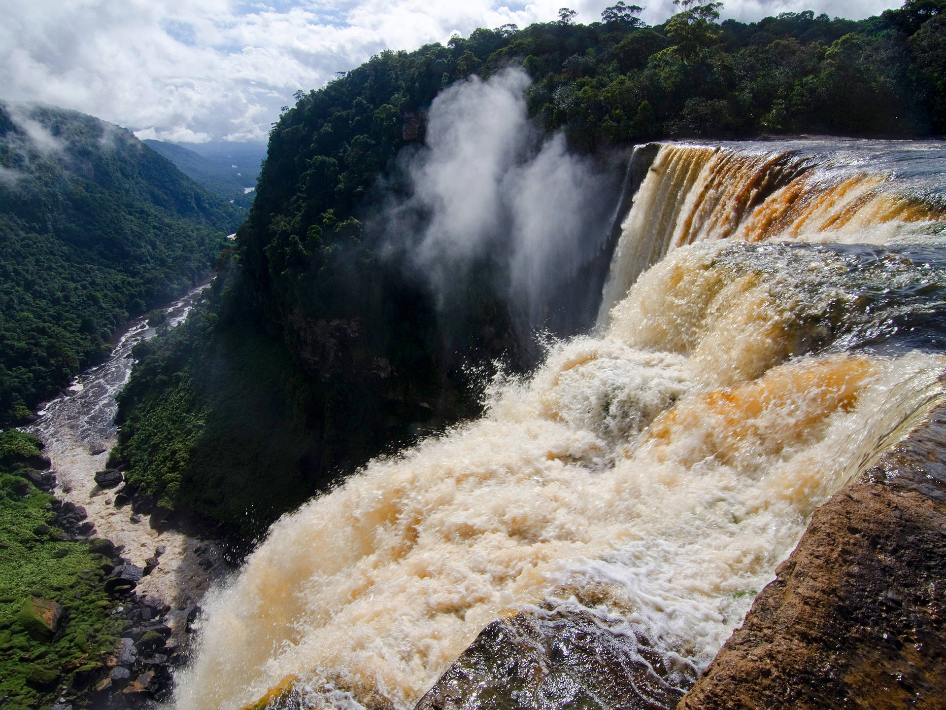 Caption: Majestic Waterfall In Natural Splendour Wallpaper