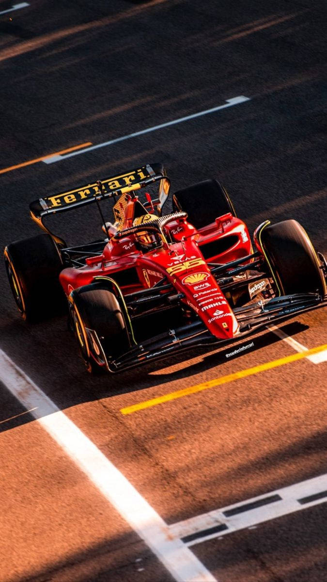 Carlos Sainz Jr. Fiercely Racing During The Golden Hour Wallpaper