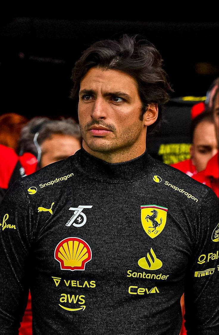 Carlos Sainz Jr. In His Black Racing Suit Wallpaper