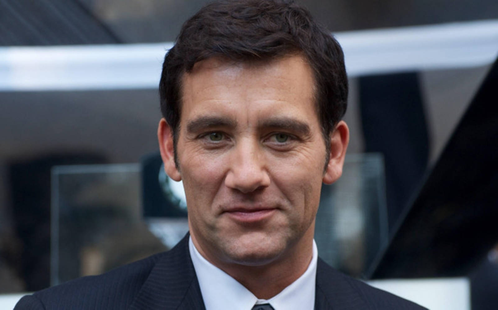 Charismatic Clive Owen Smiling Wallpaper