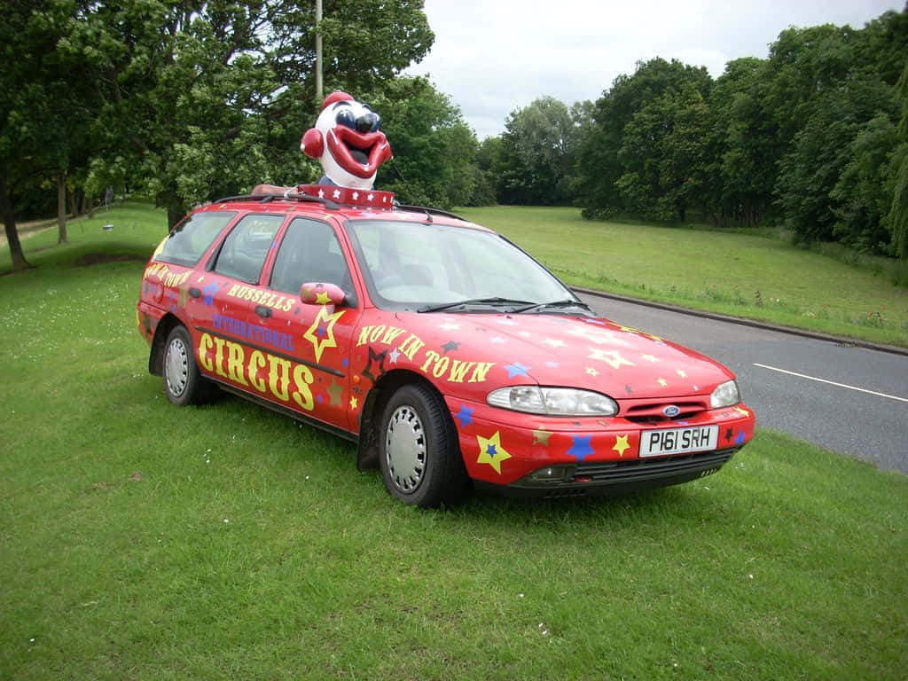 Circus Themed Clown Car Parked On Grass Wallpaper