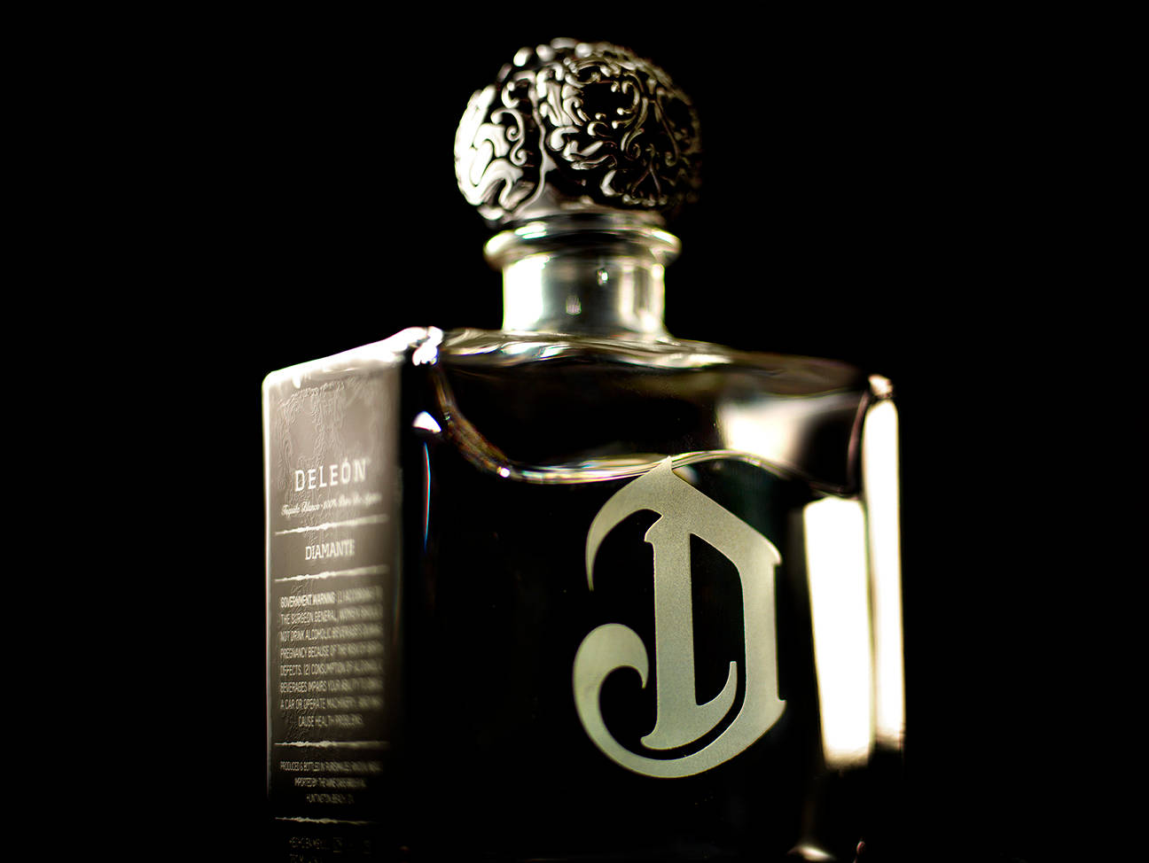 Close-up View Of Deleon Tequila Bottle And Logo Wallpaper