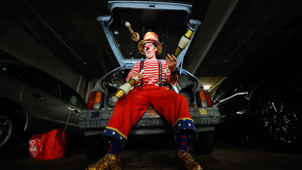 Clown Juggling Act From Car Trunk Wallpaper