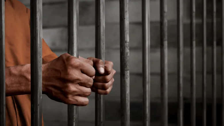 Cooped Up Freedom- Prisoner Holding Bars Wallpaper