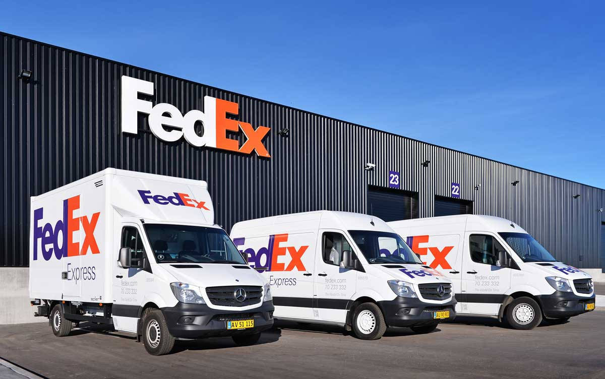 Fedex Tracking Vehicles Near Warehouse Wallpaper