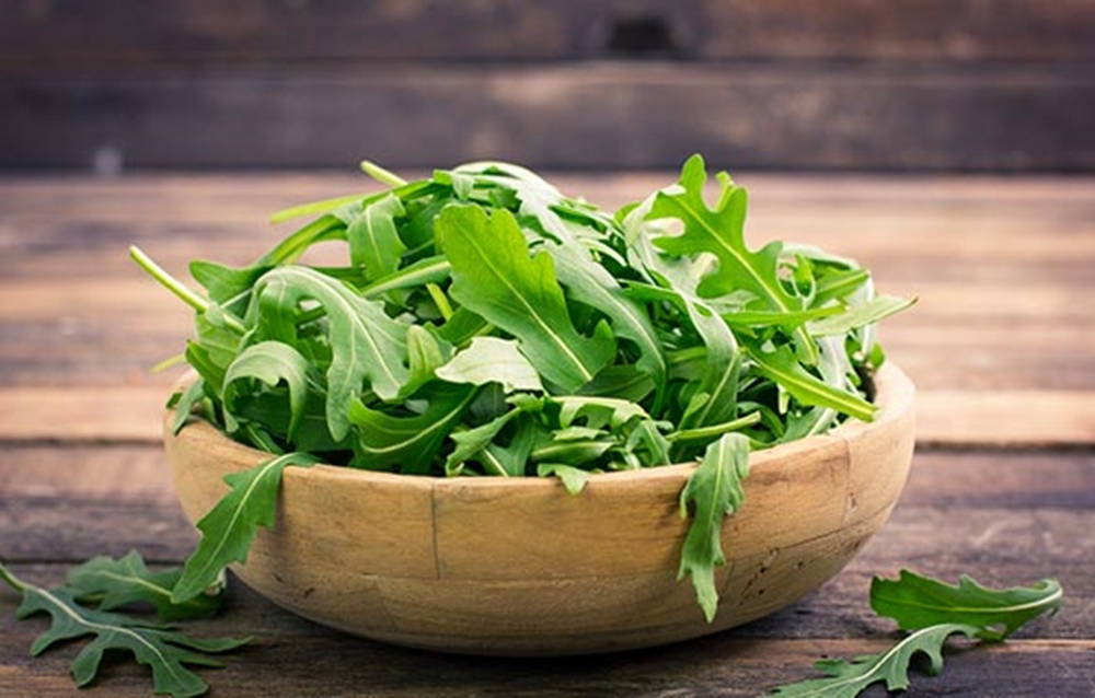 Fresh Arugula Leaves In A Wooden Bowl Wallpaper