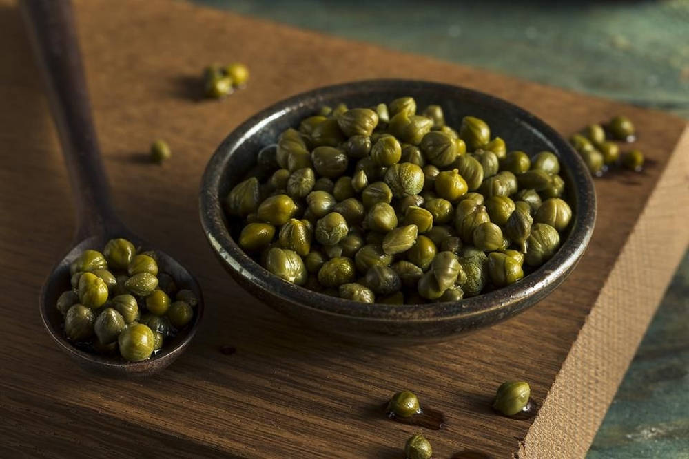 Fresh Capers In A Dark Soup Bowl Wallpaper