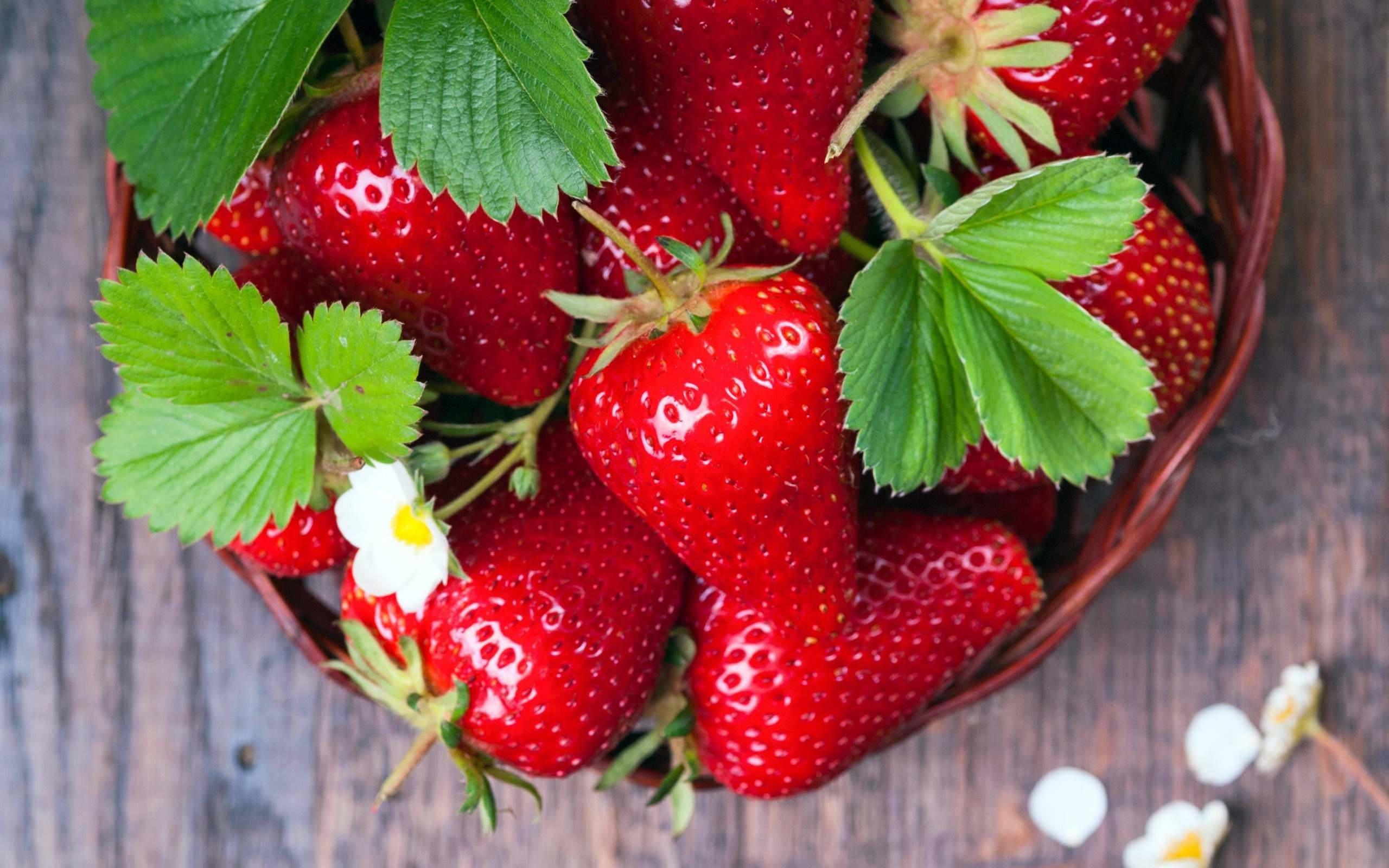 Fresh Strawberries In A Woven Bowl On A Desktop Wallpaper