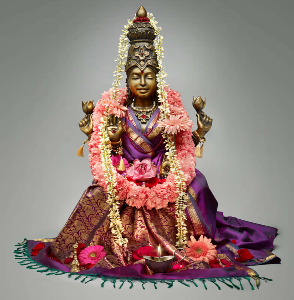 Goddess Mahalakshmi Statue Adorned With Flowers Wallpaper