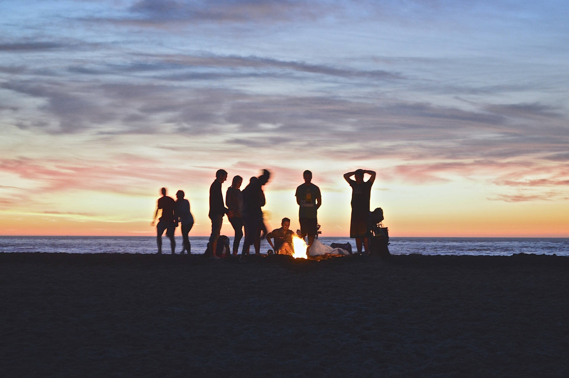 Group Of People Around A Campire Wallpaper