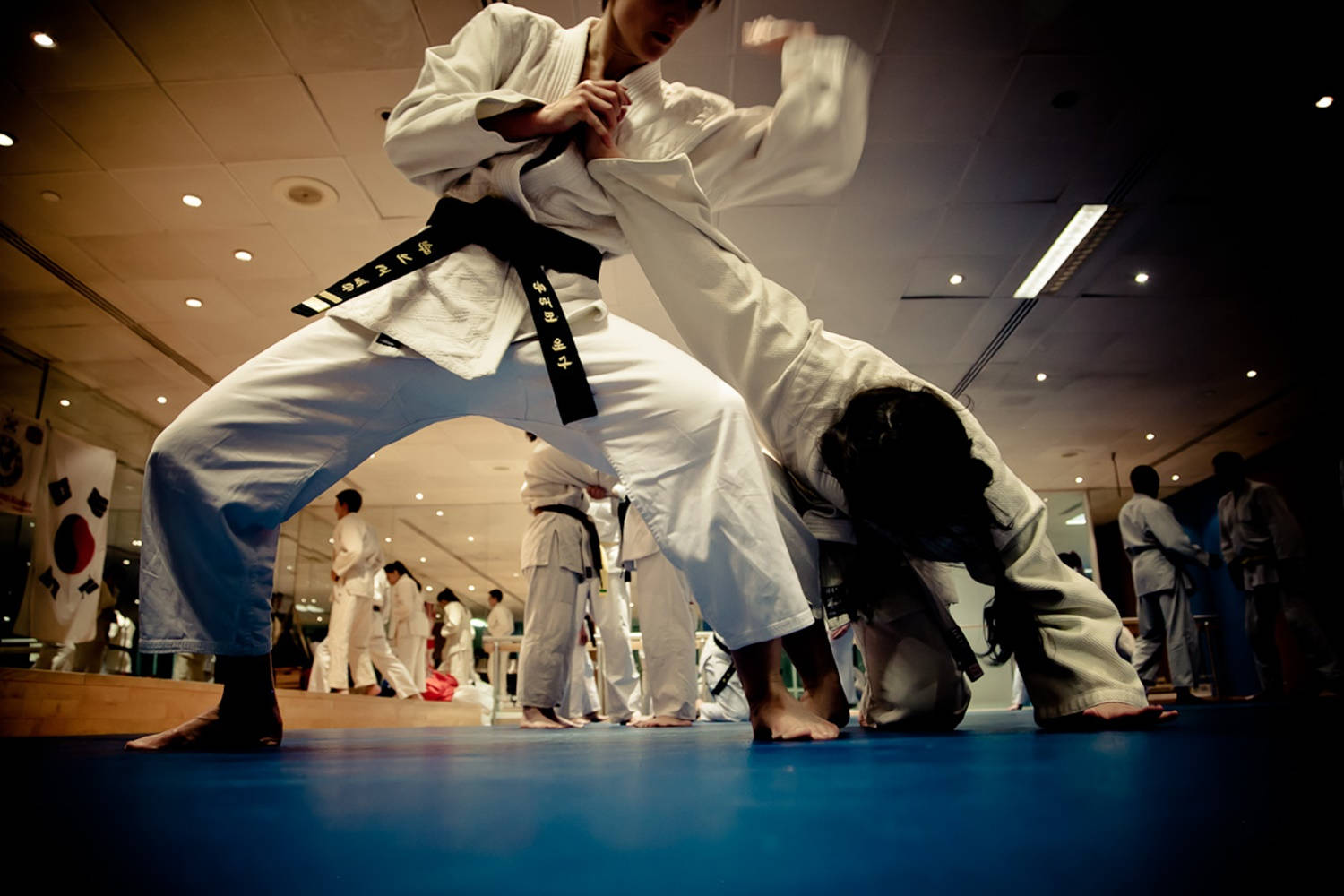 Hapkido Master Demonstrating A Wrist-lock Technique In Class Wallpaper