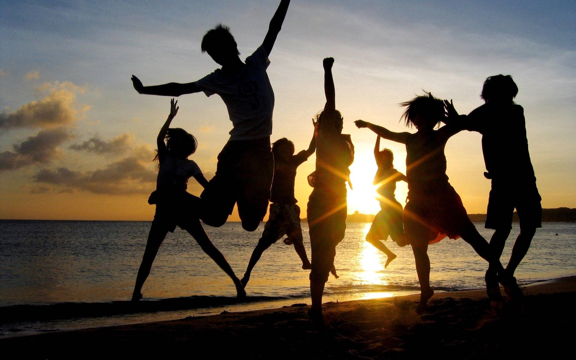 Happy Beach Goers Jump Shot Wallpaper