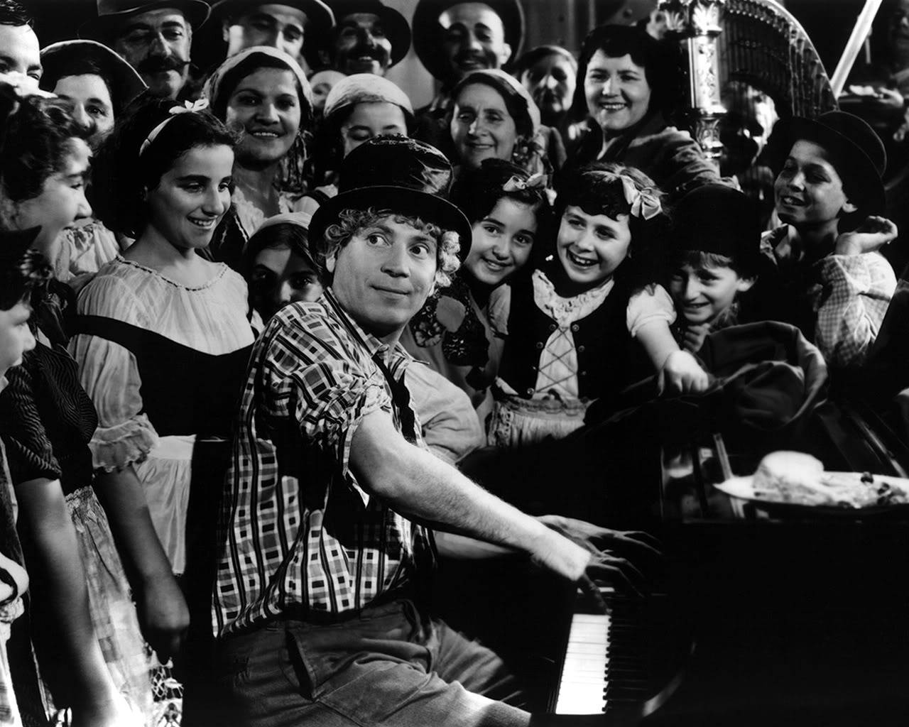 Harpo Marx Of The Marx Brothers Joyfully Playing The Piano Wallpaper