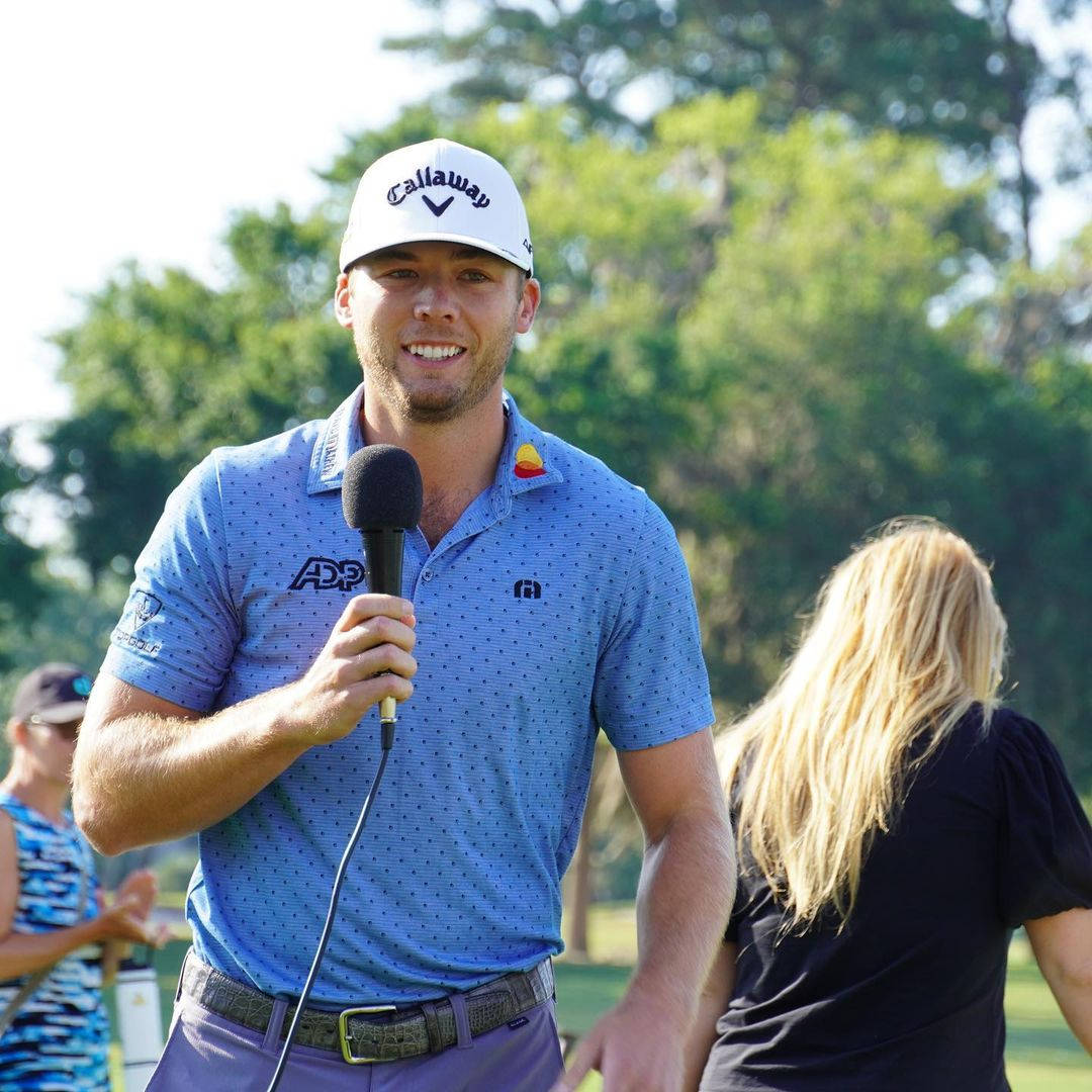 Inspiring Champion; Sam Burns Holding A Microphone Wallpaper