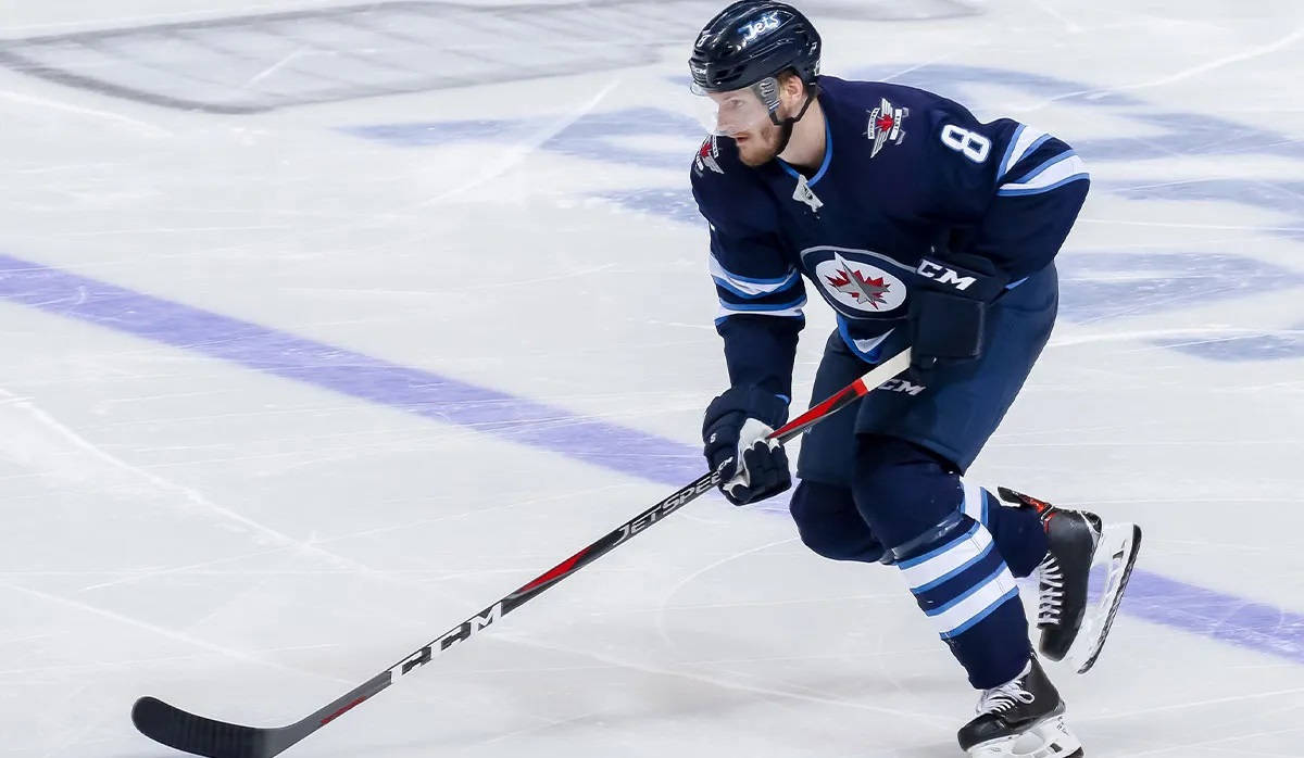 Jacob Trouba Gliding On Ice While Holding Hockey Stick In Front During Game Wallpaper