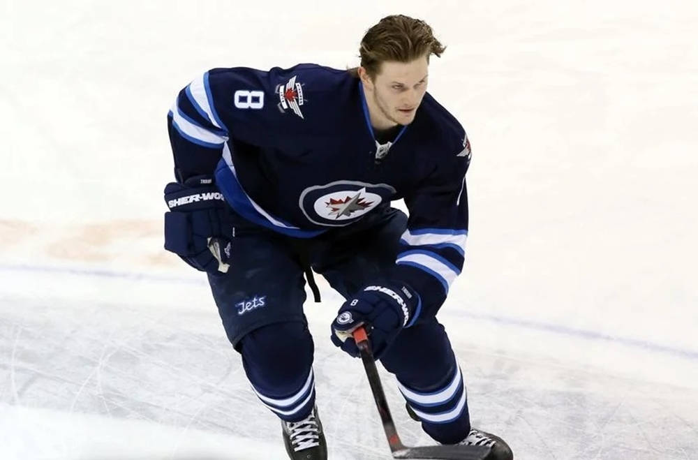 Jacob Trouba Gliding On Ice Without Helmet While Raising Hockey Stick Wallpaper