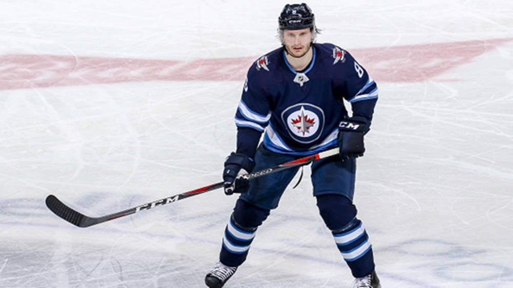 Jacob Trouba Raising His Hockey Stick During A Game Wallpaper