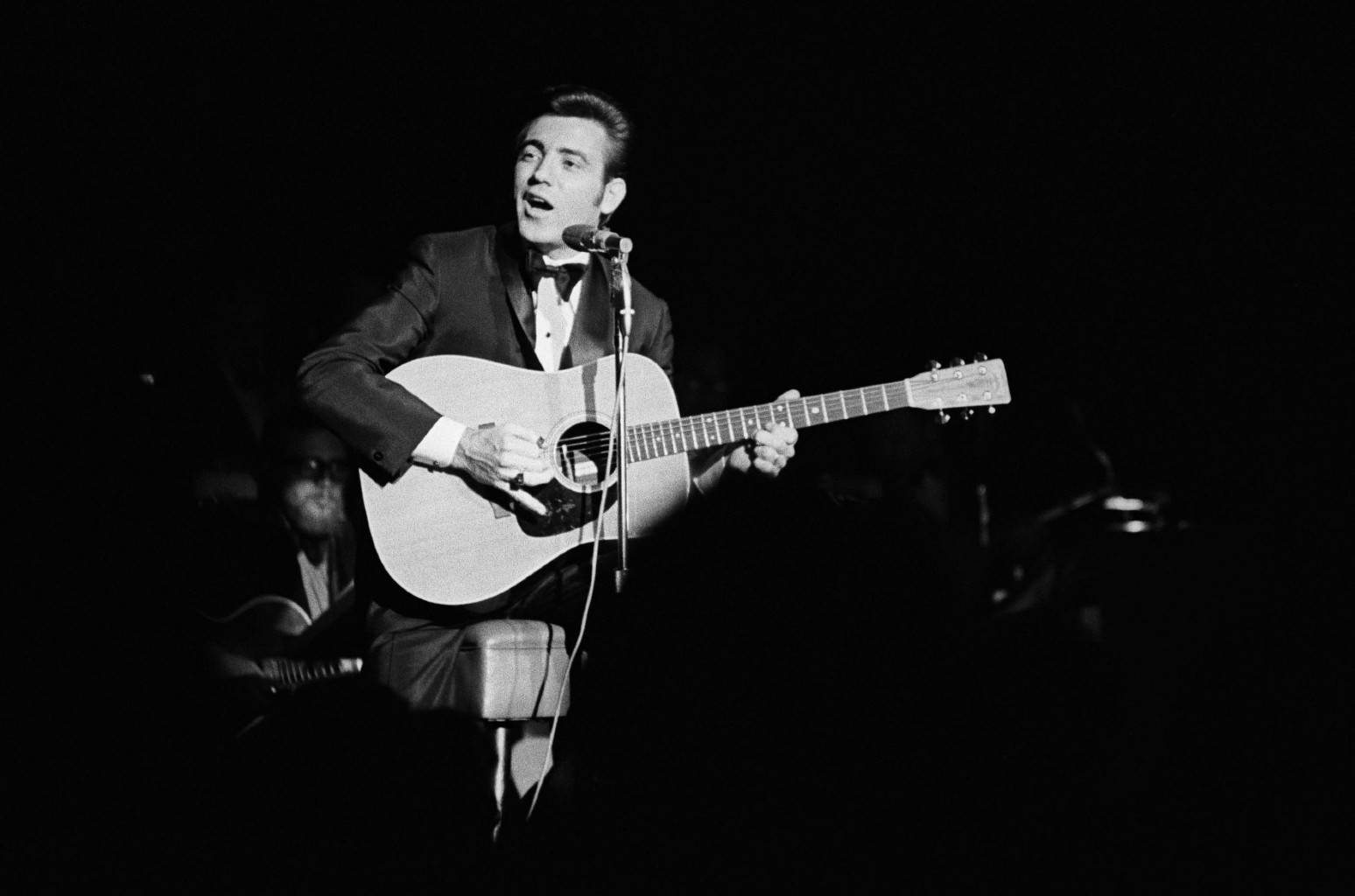 Jimmie Rodgers Performing On A Dark Stage Wallpaper