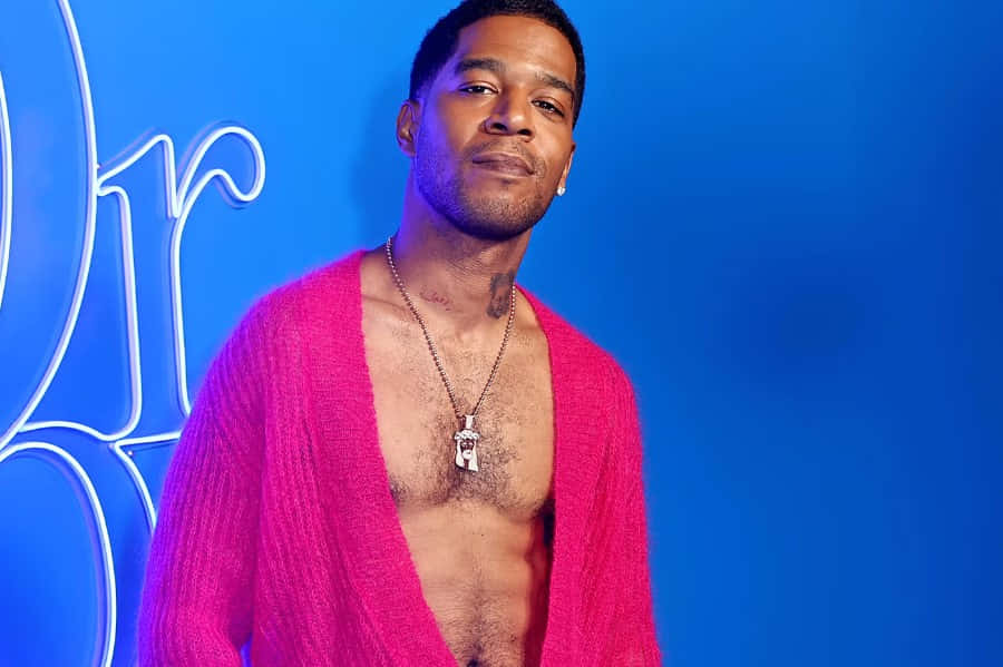 Kid Cudi Pink Cardigan Blue Backdrop Wallpaper